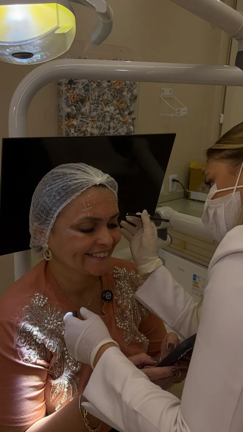 Paciente sorrindo durante a marcação, no consultório da Dra. Letícia Marques